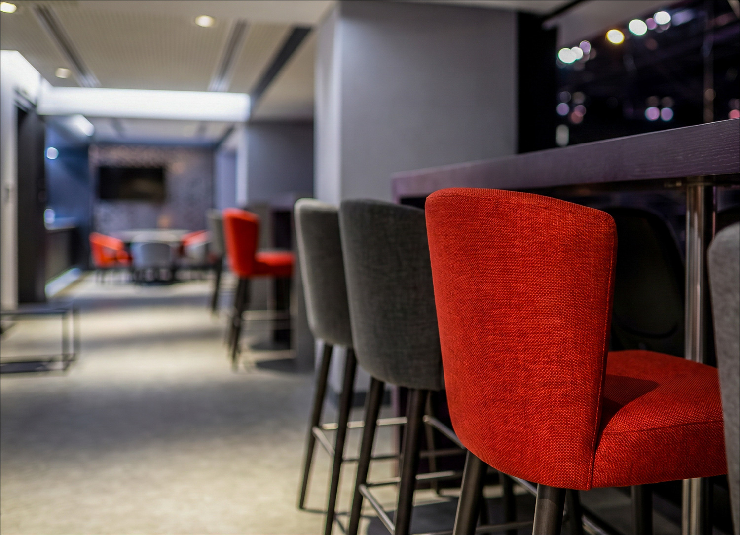 Red upholstered stools at the VIP suite bar
