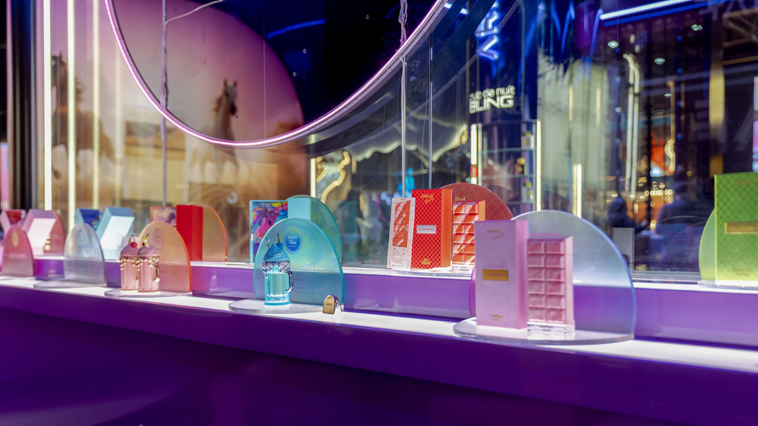 Colourful ARMAF fragrance bottles in illuminated display